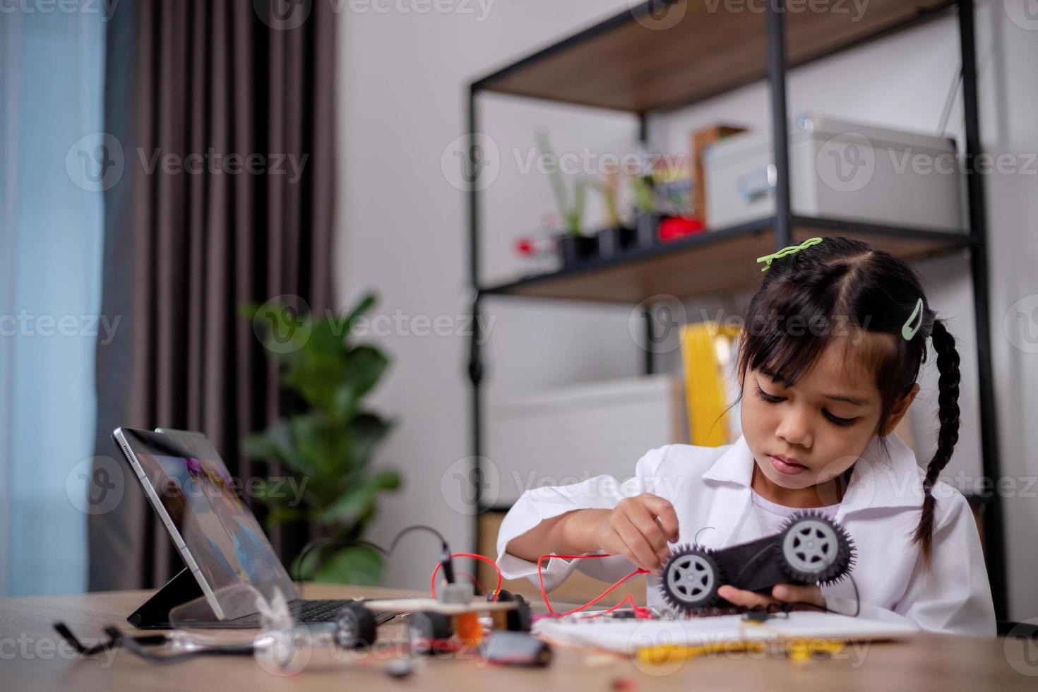Asian students learn at home by coding robot cars and electronic board cables in STEM, STEAM, mathematics engineering science technology computer code in robotics for kids' concepts. photo