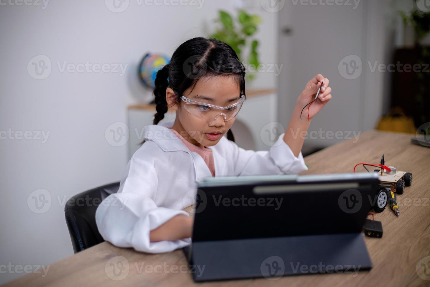 Asian students learn at home by coding robot cars and electronic board cables in STEM, STEAM, mathematics engineering science technology computer code in robotics for kids' concepts. photo