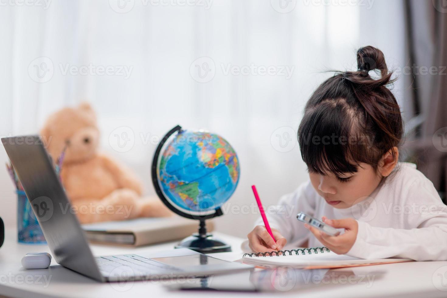 Asian little girl is learning the globe model, concept of save the world and learn through play activity for kid education at home. photo