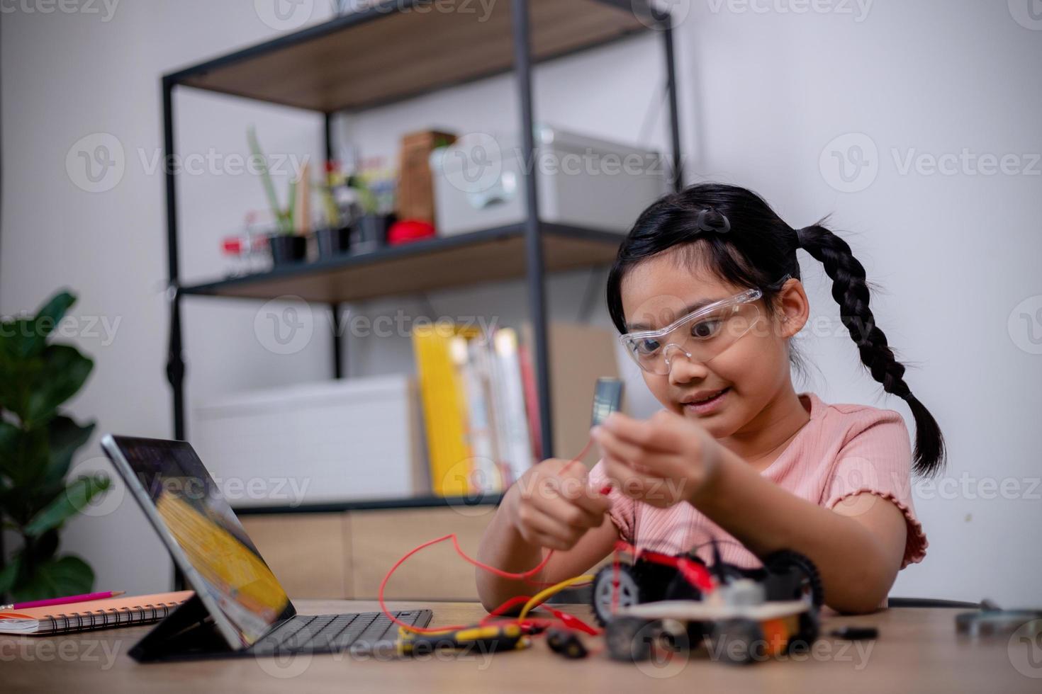 Asian students learn at home by coding robot cars and electronic board cables in STEM, STEAM, mathematics engineering science technology computer code in robotics for kids' concepts. photo