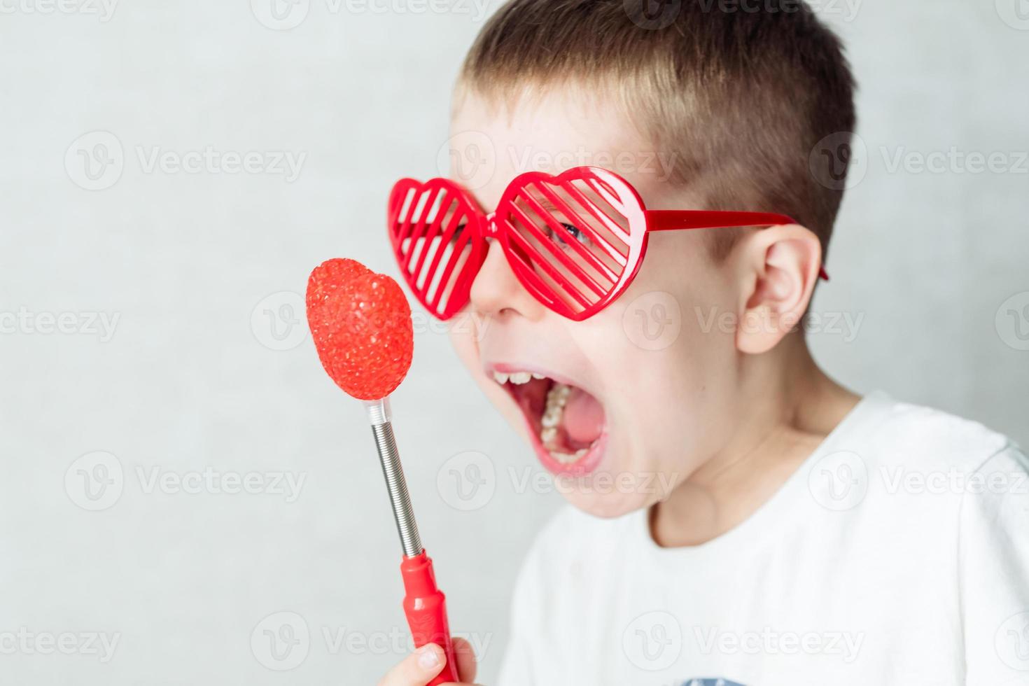 portrait of a boy in glasses in the form of a heart in a white T-shirt against a white background, screaming at the heart. Against valentine's day photo