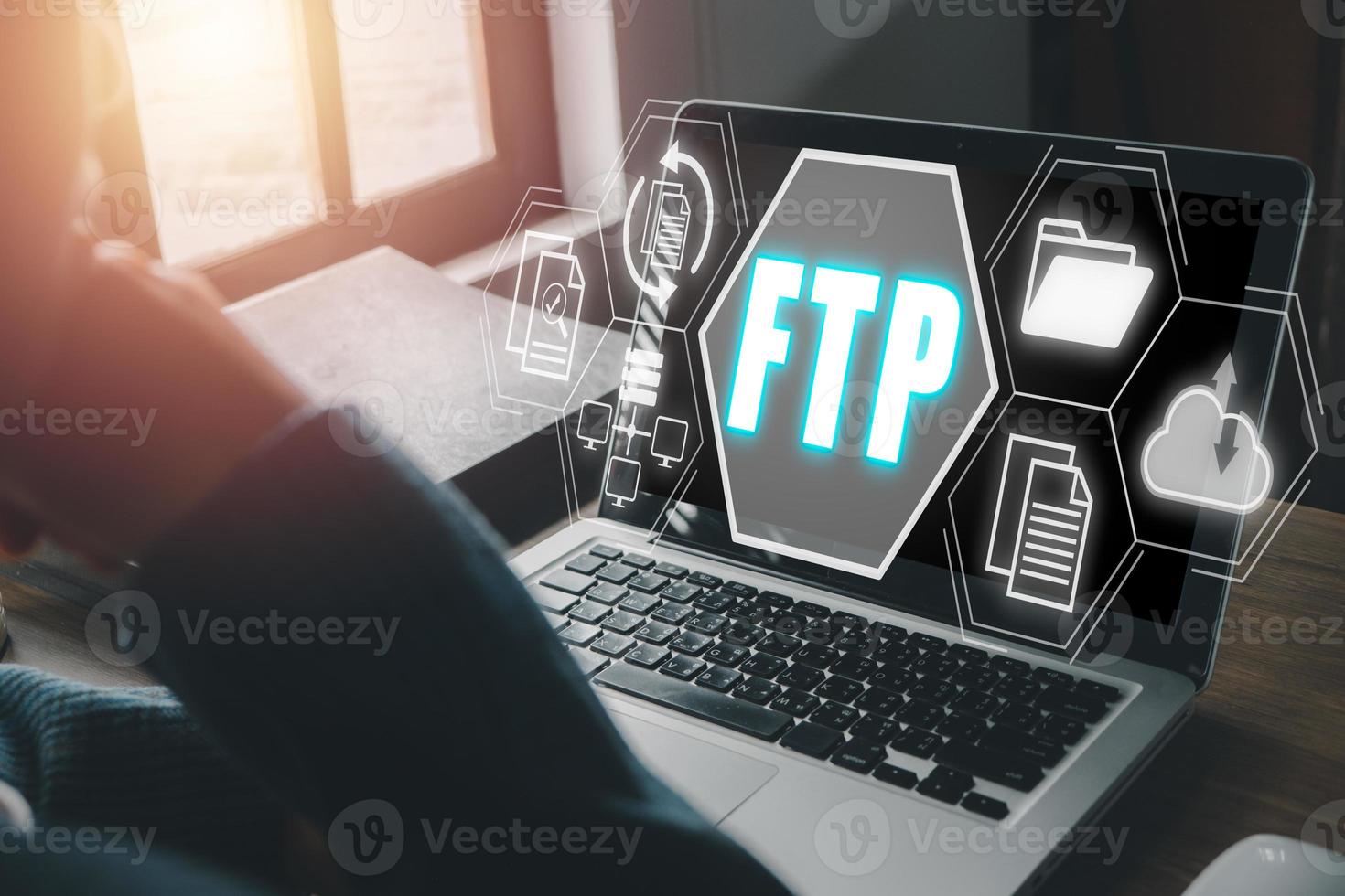 FTP, File transfer protocol, Person using laptop computer on desk with File transfer protocol icon on virtual screen, Internet and communication technology concept. photo