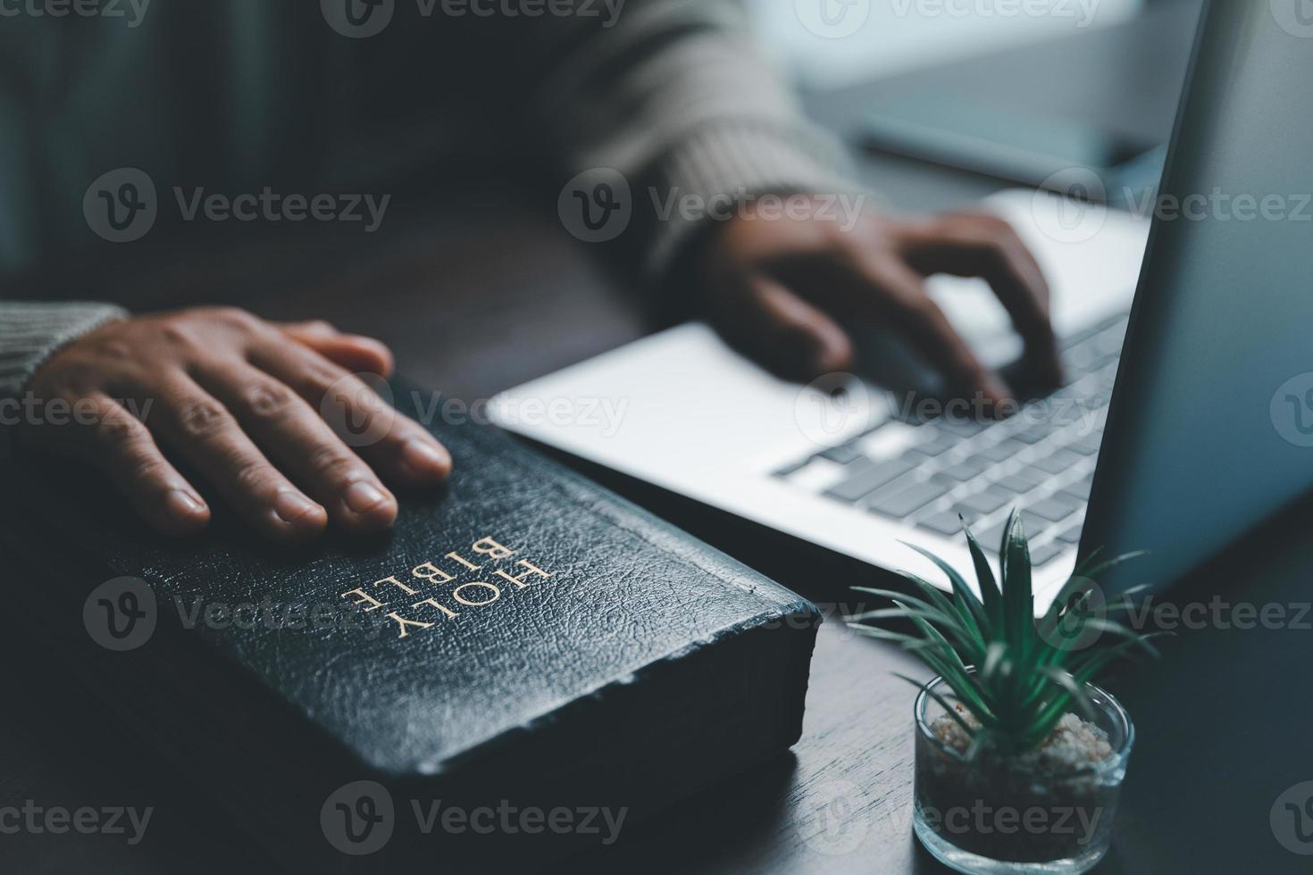 Christian online technology concept. Hands praying of christian with digital computer laptop, Online live church for sunday service. Asian catholic woman are reading Holy bible book and online study. photo