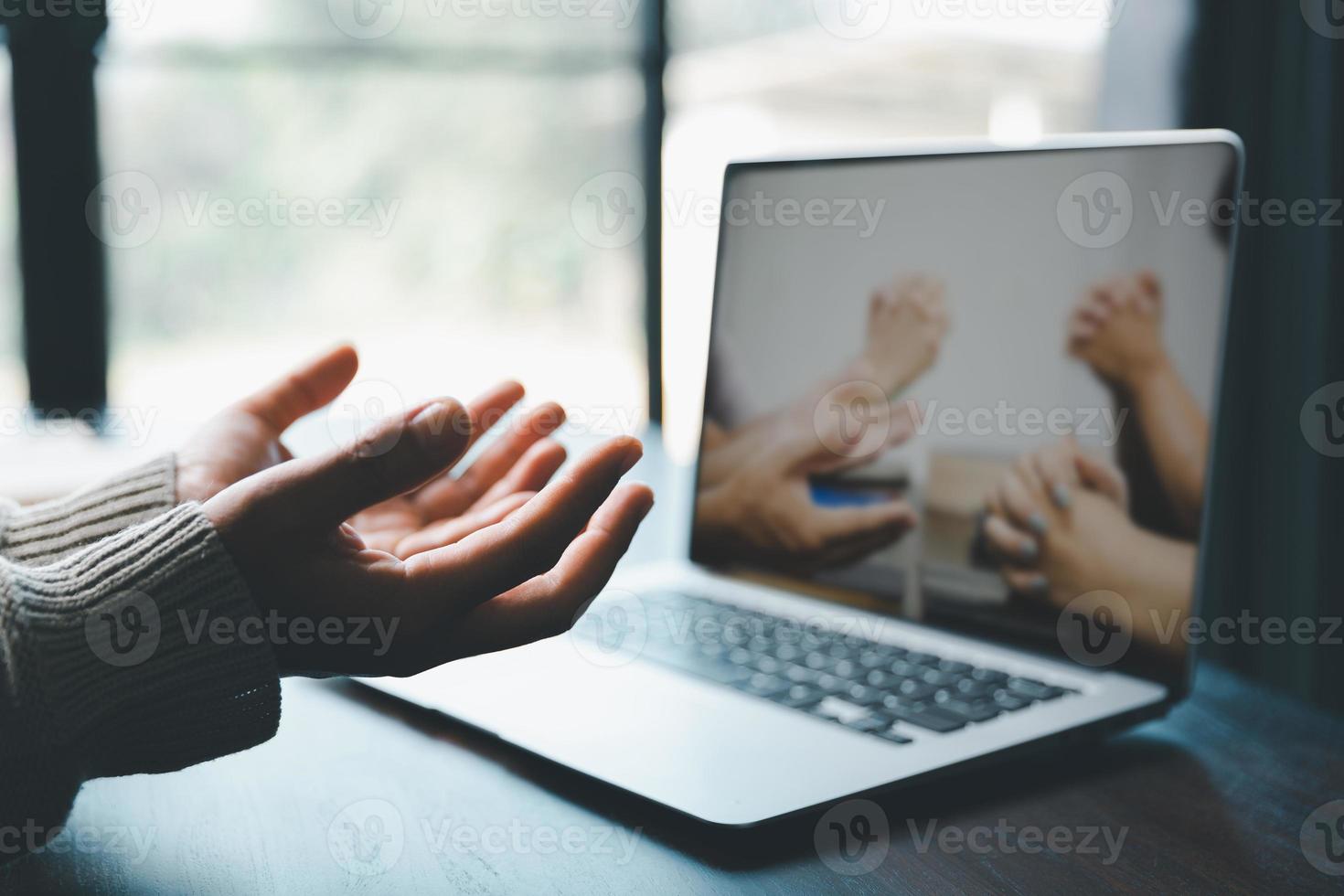 Christian online technology concept. Hands praying of christian with digital computer laptop, Online live church for sunday service. Asian catholic woman are reading Holy bible book and online study. photo