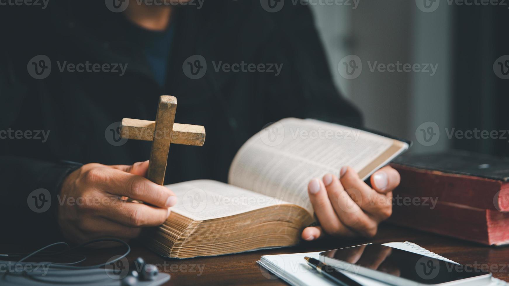 Christian online technology concept. Hands praying of christian with digital computer laptop, Online live church for sunday service. Asian catholic man are reading Holy bible book and online study. photo