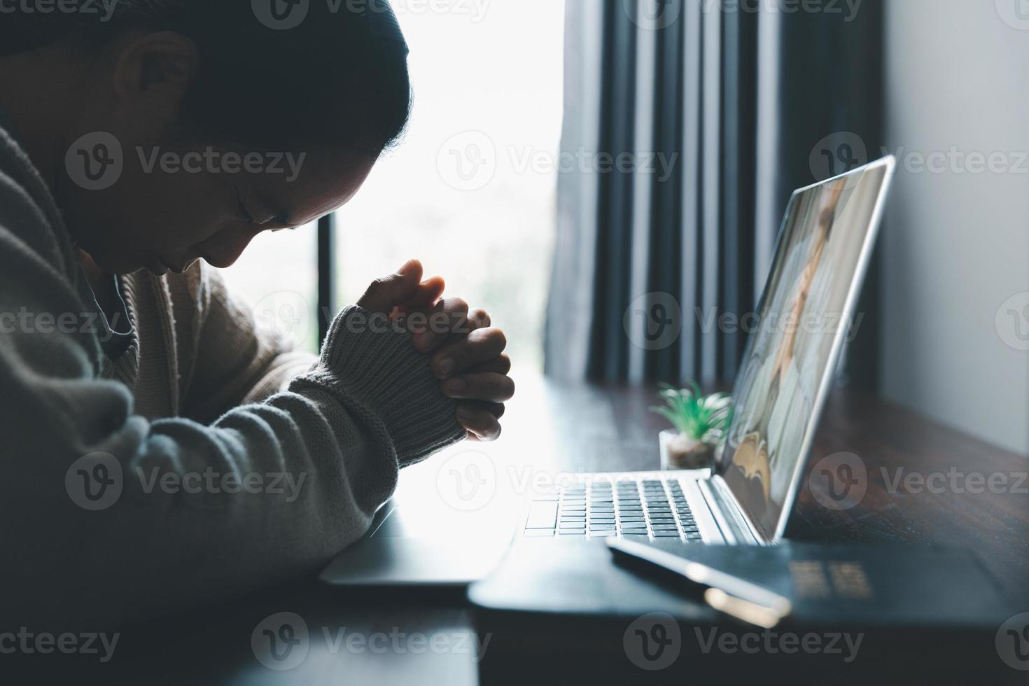 Christian online technology concept. Hands praying of christian with digital computer laptop, Online live church for sunday service. Asian catholic woman are reading Holy bible book and online study. photo