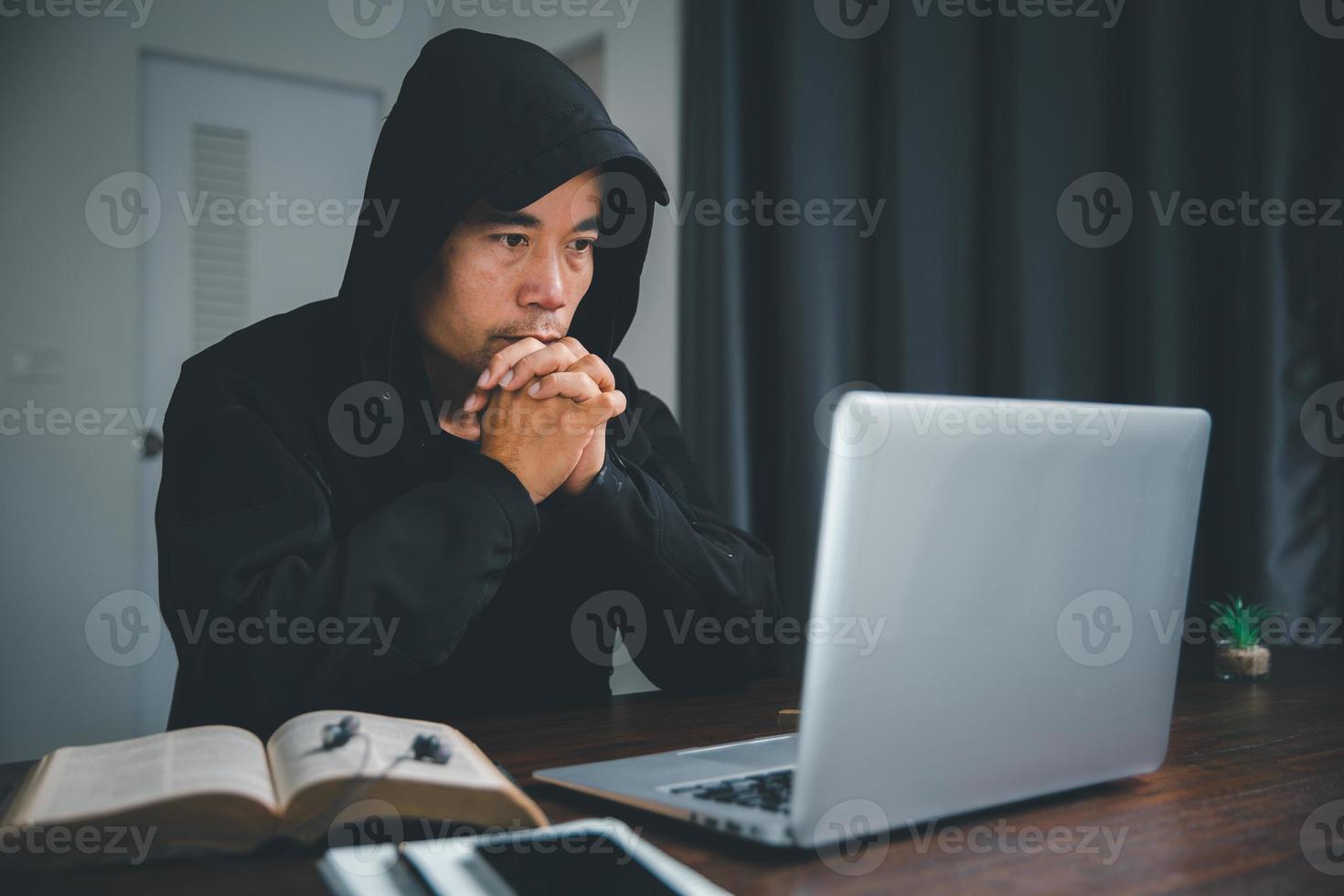 Christian online technology concept. Hands praying of christian with digital computer laptop, Online live church for sunday service. Asian catholic man are reading Holy bible book and online study. photo