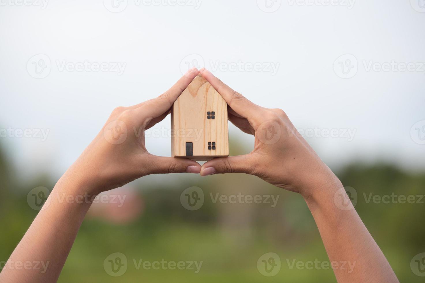 new home concept - young family with dream house scale model in hands photo