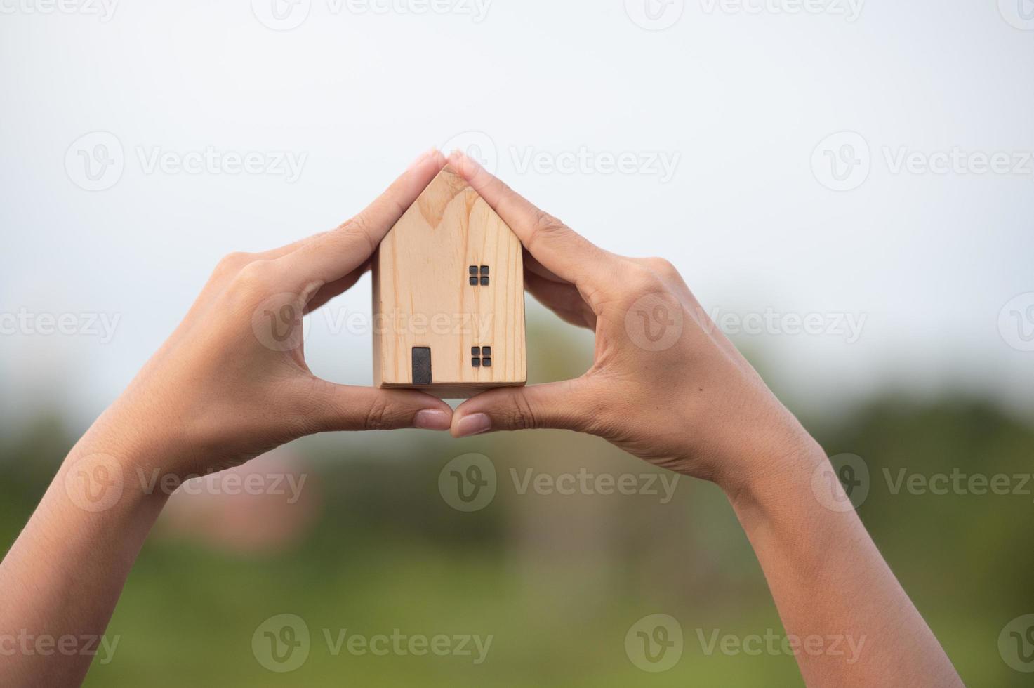 new home concept - young family with dream house scale model in hands photo