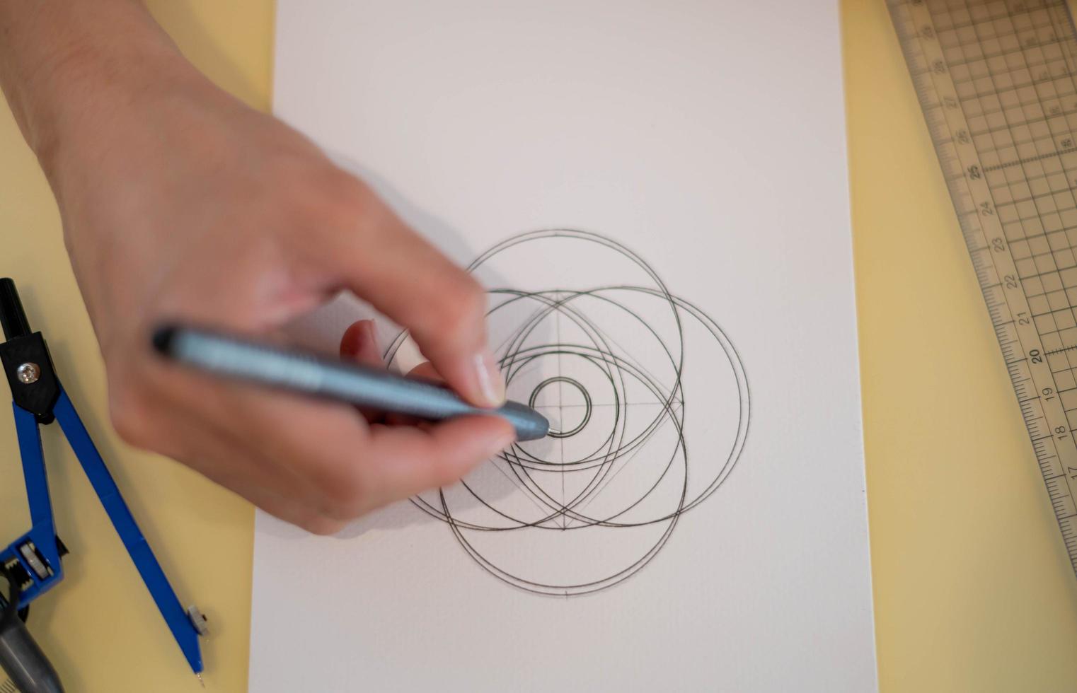 Female hand using a black magic pen preparing to draw and sketch the mandala concept on the empty white paper. photo