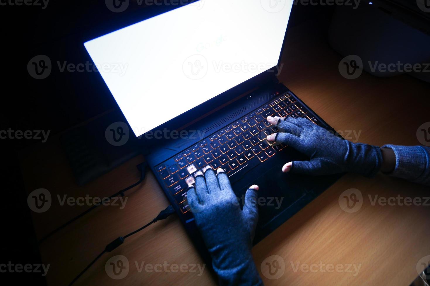 hacker hand stealing data from laptop top down photo