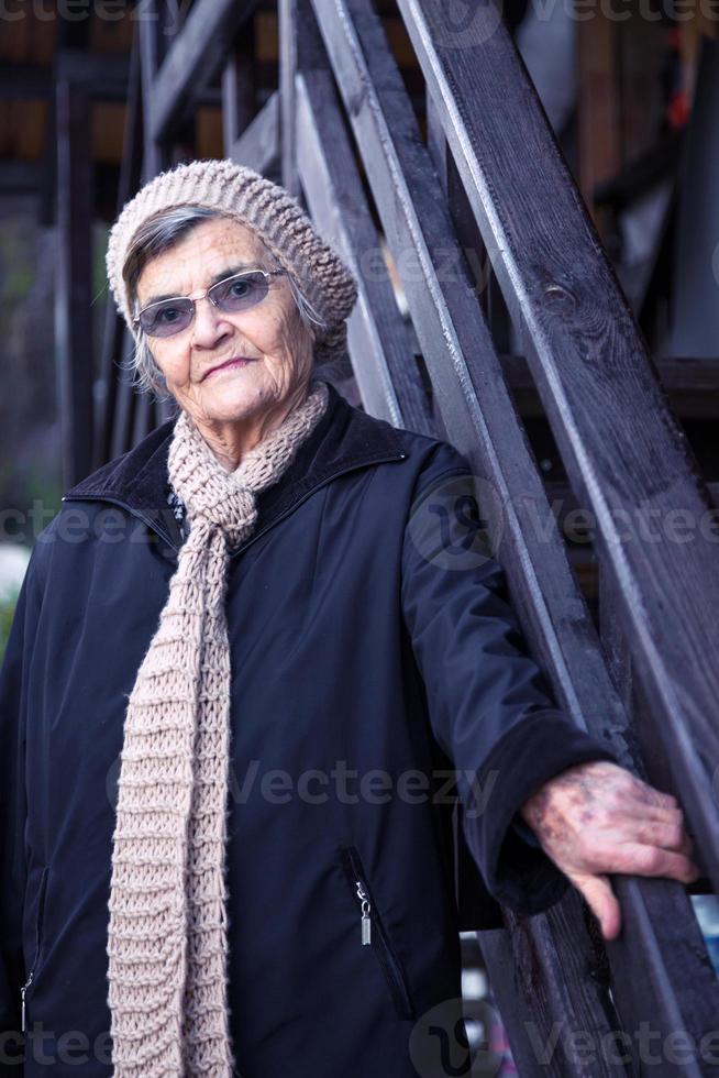 retrato de una anciana con sombrero y gafas en la calle foto