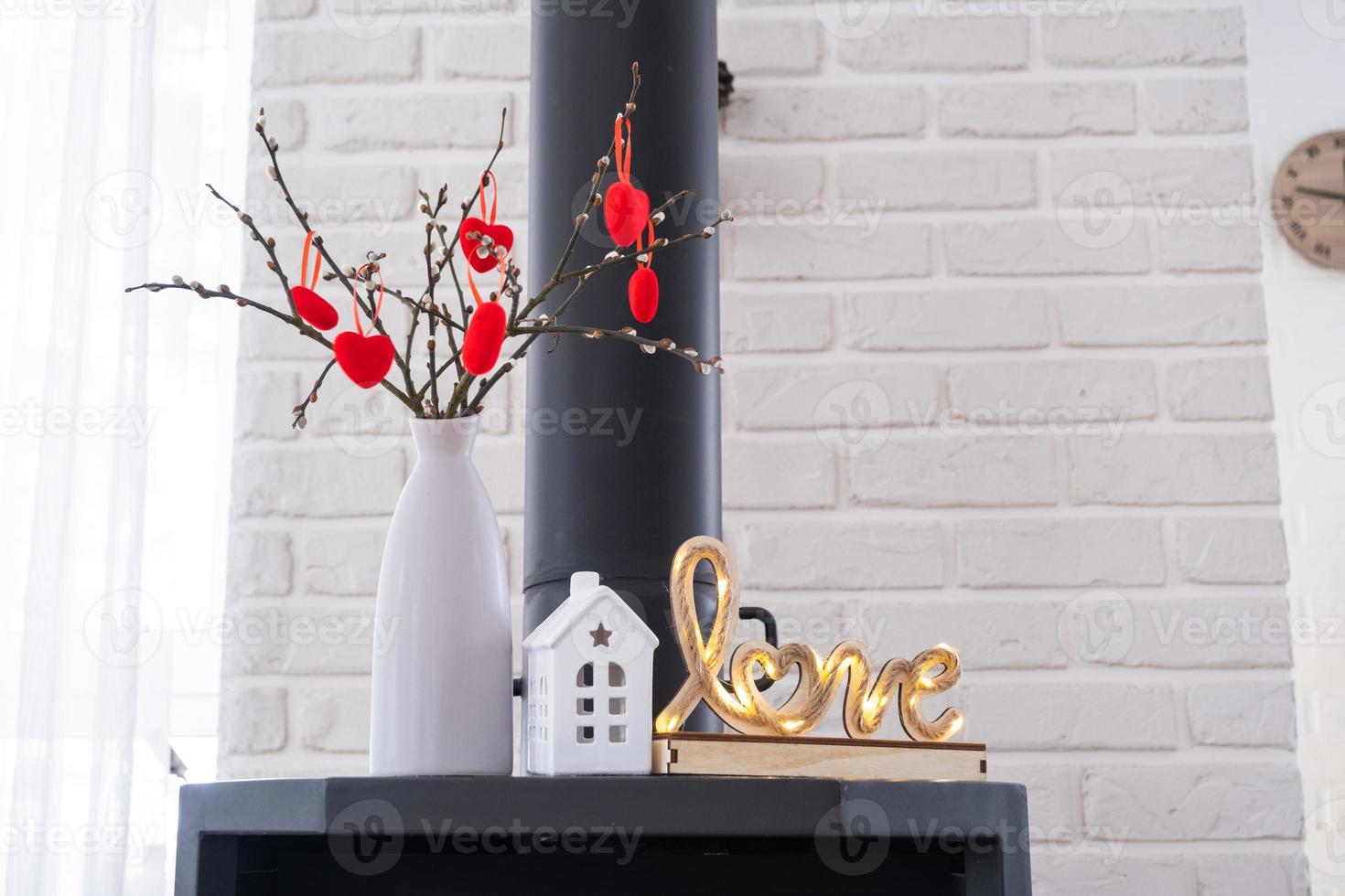 Valentine decor near fireplace stove with fire and firewood. Cozy ...