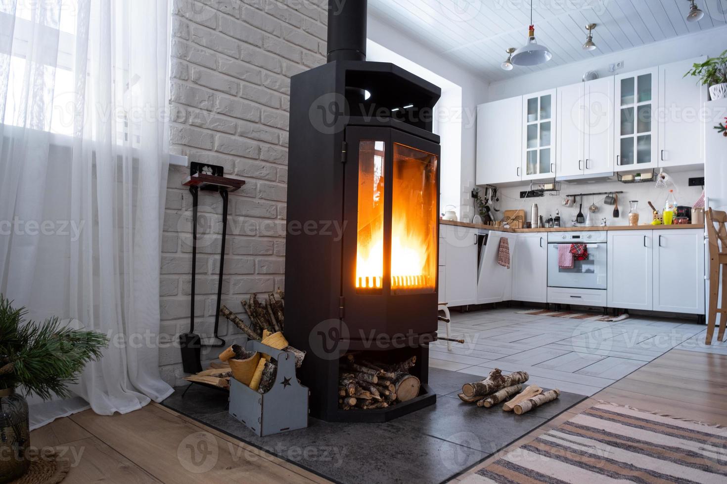Black stove, fireplace in interior of house in loft style. Alternative eco-friendly heating, warm cozy room at home, burning wood photo