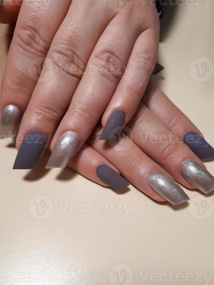 Acrylic nail extension, manicure, nail correction, hands in the foreground. Reflective design. photo