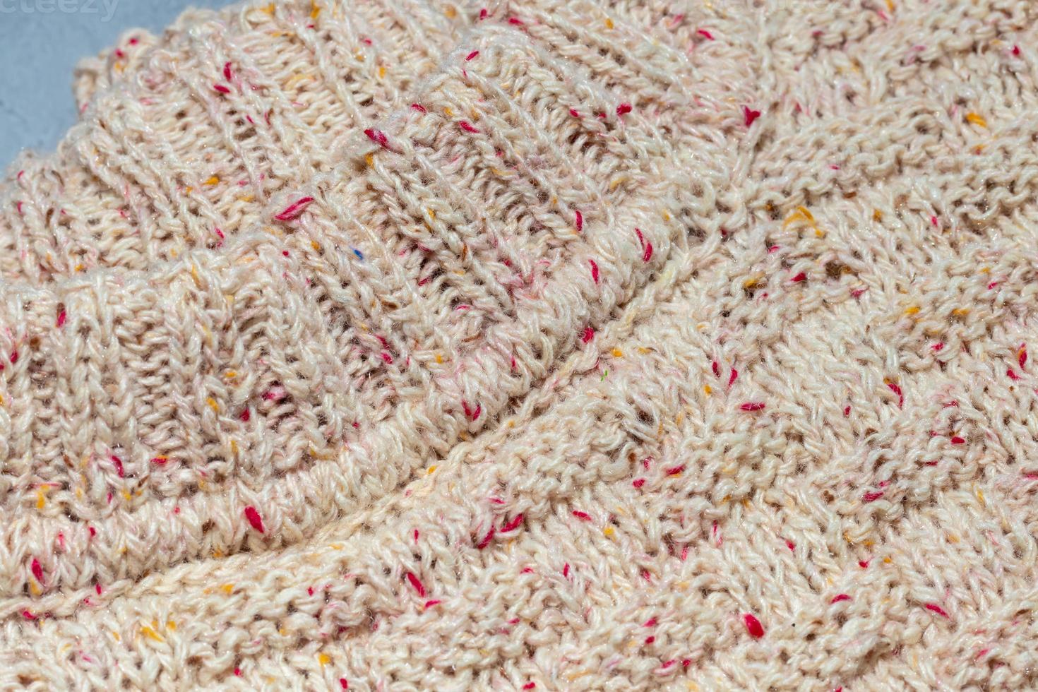 Knitted handmade items. Knitted fabric from colored thread. Bright background. photo