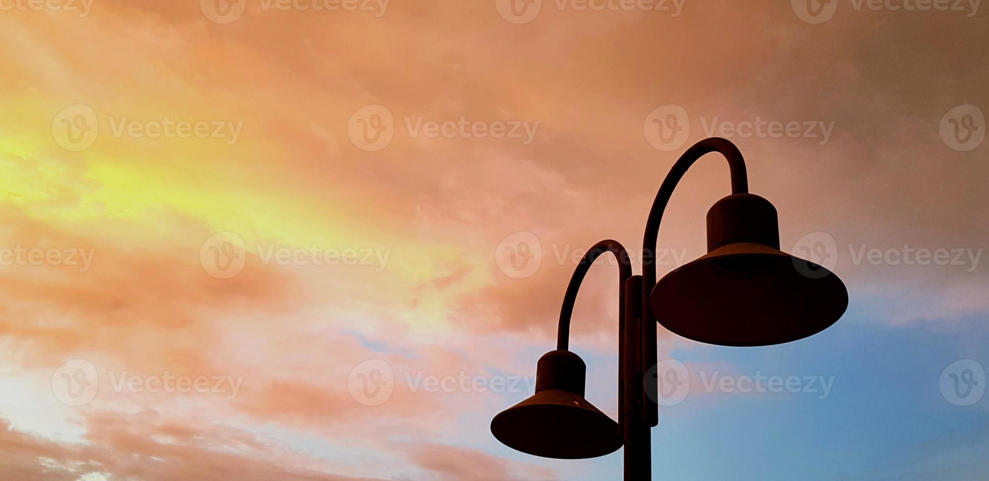 silueta de poste de luz con cielo colorido del amanecer al atardecer o al amanecer y espacio de copia izquierdo. belleza de la naturaleza y el concepto de objeto foto