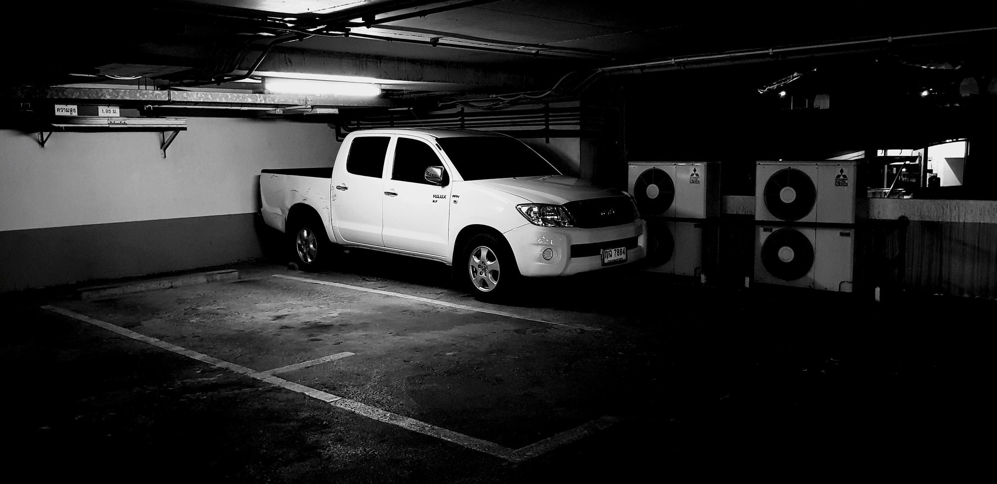Bangkok, Thailand - January 30, 2023 White car on parking lot in building with neon light in black and white style. Vehicle, Transportation and Art concept photo