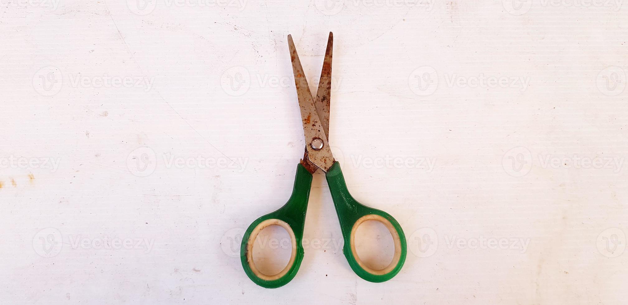 Old green rusty scissor putting or isolated on white board background. Vintage or Single object concept photo