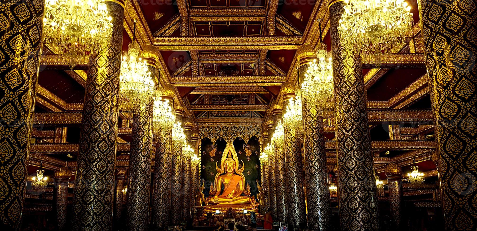 Big golden monk statue at Phitsanulok, Thailand. Beautiful interior design and art building in Thai ancient style. Landmark of travel for tourism people. photo