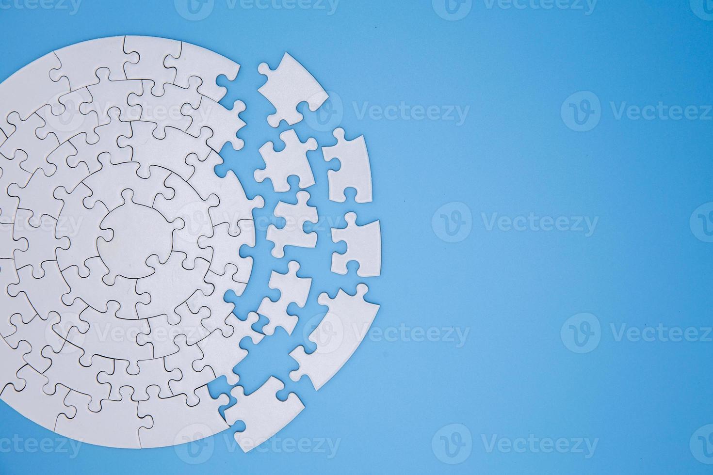 Unfinished white jigsaw puzzle pieces on blue background, The last piece of jigsaw puzzle, Copy space. photo