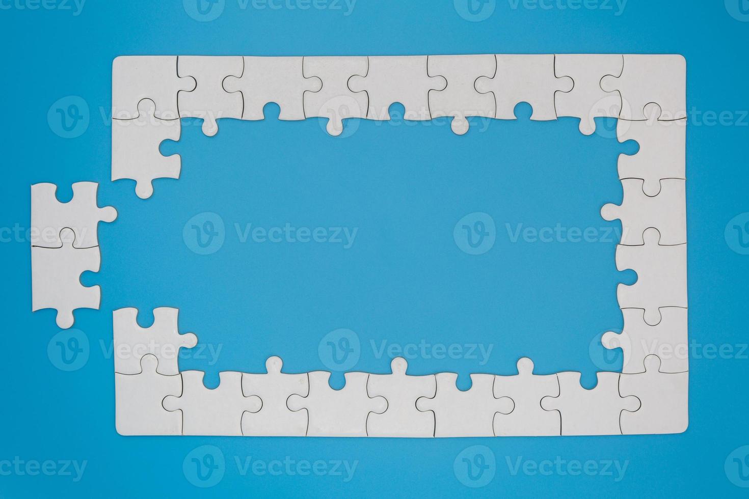 White jigsaw puzzle on blue background, Copy space. photo