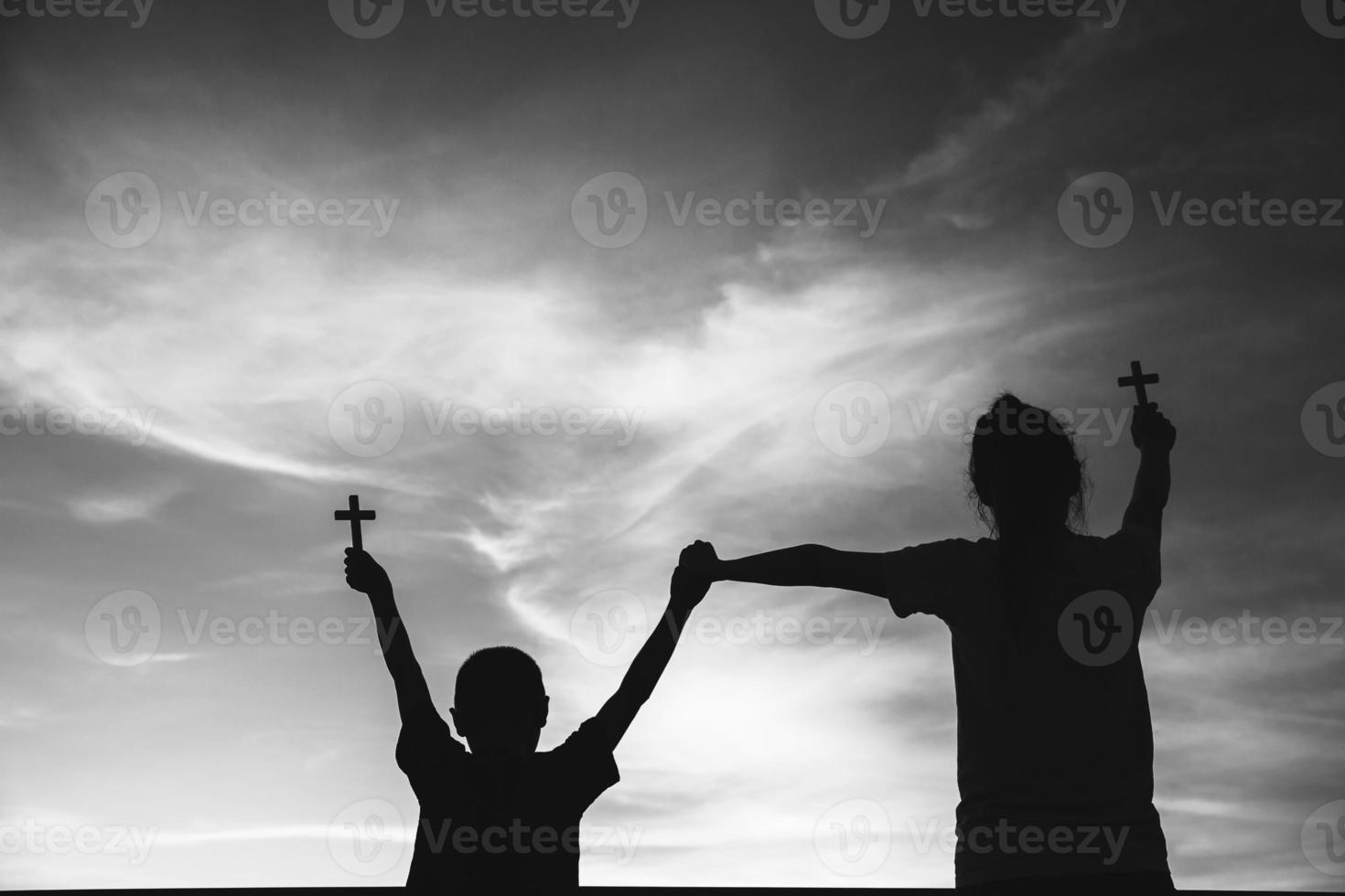 Two children worship God by holding christian Cross, christian concept. photo