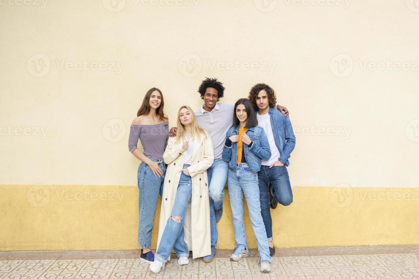 Grupo multiétnico de amigos posando mientras se divierten y ríen juntos foto