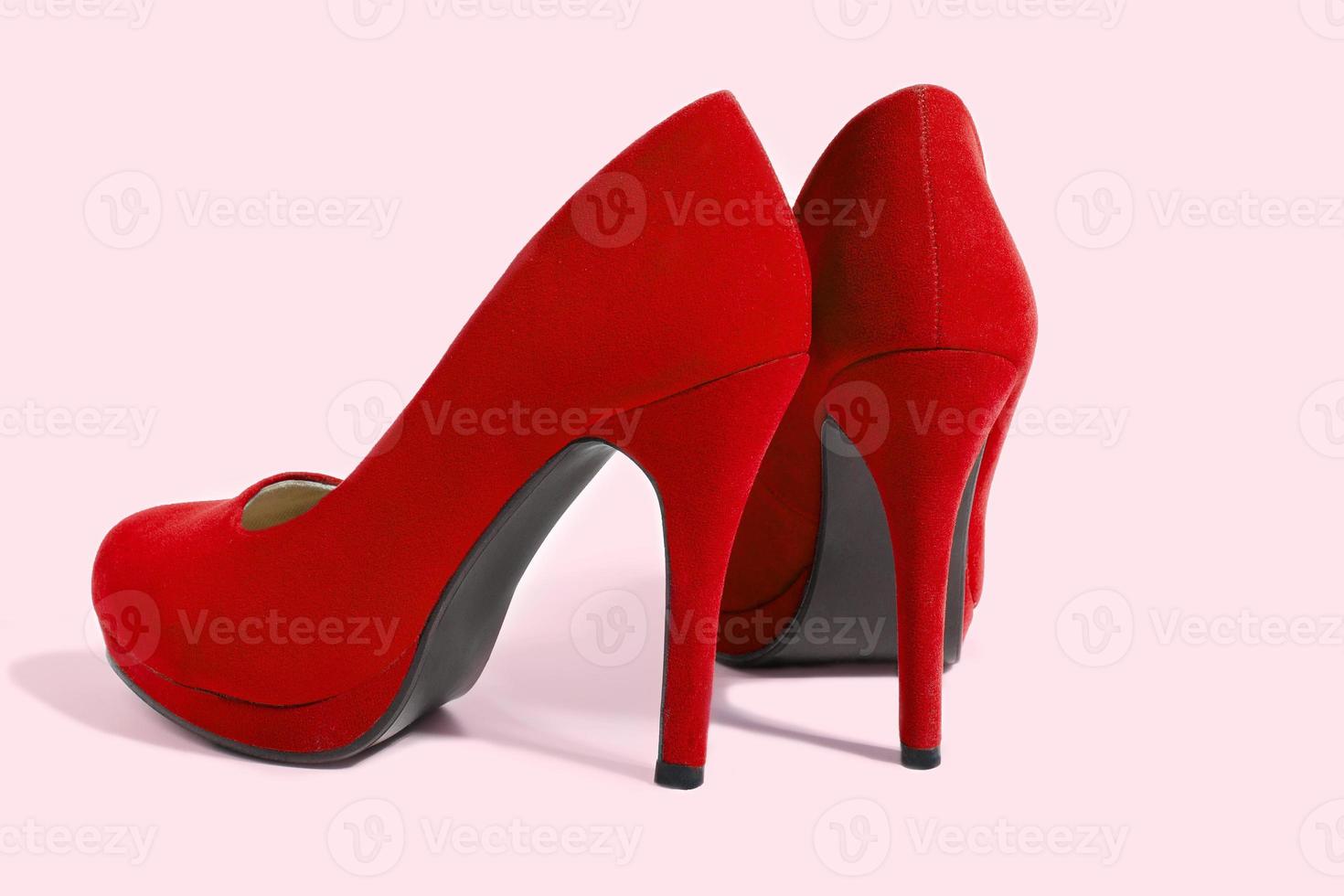 Red Woman Fashion High Heels Shoes Isolated On Pink Background. Closeup women bright summer footwear. Shopping and Fashion concept. Glamour and luxury ladies accessory. Selective focus photo