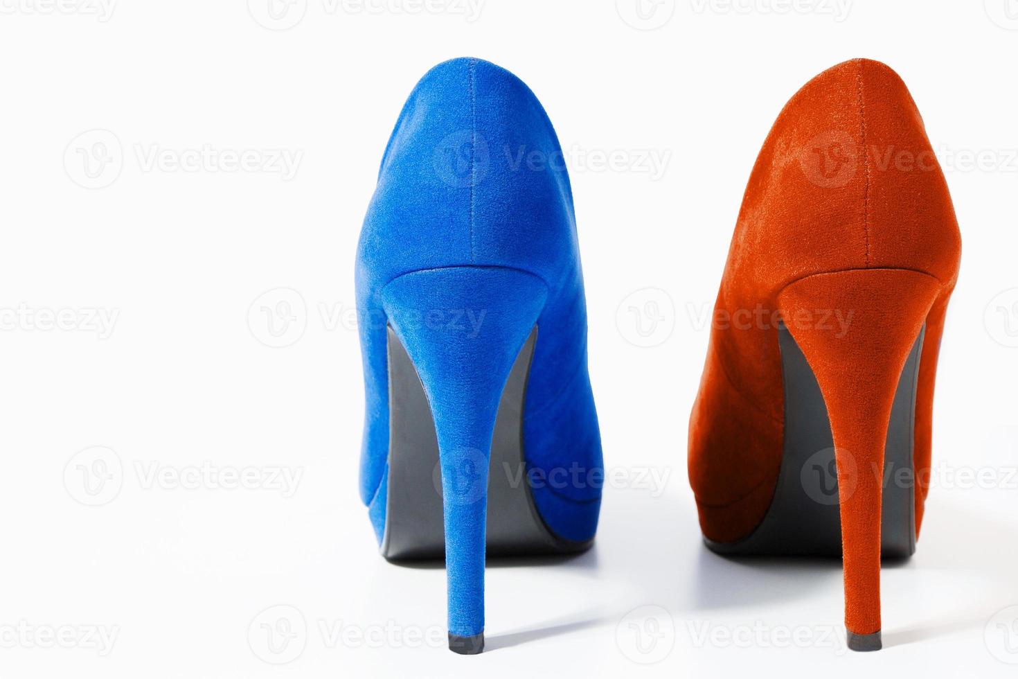 Closeup of fashionable high heels red and blue shoes isolated on white background. Blue color woman shoe on floor. Shopping and fashion concept. Copy space. Selective focus photo