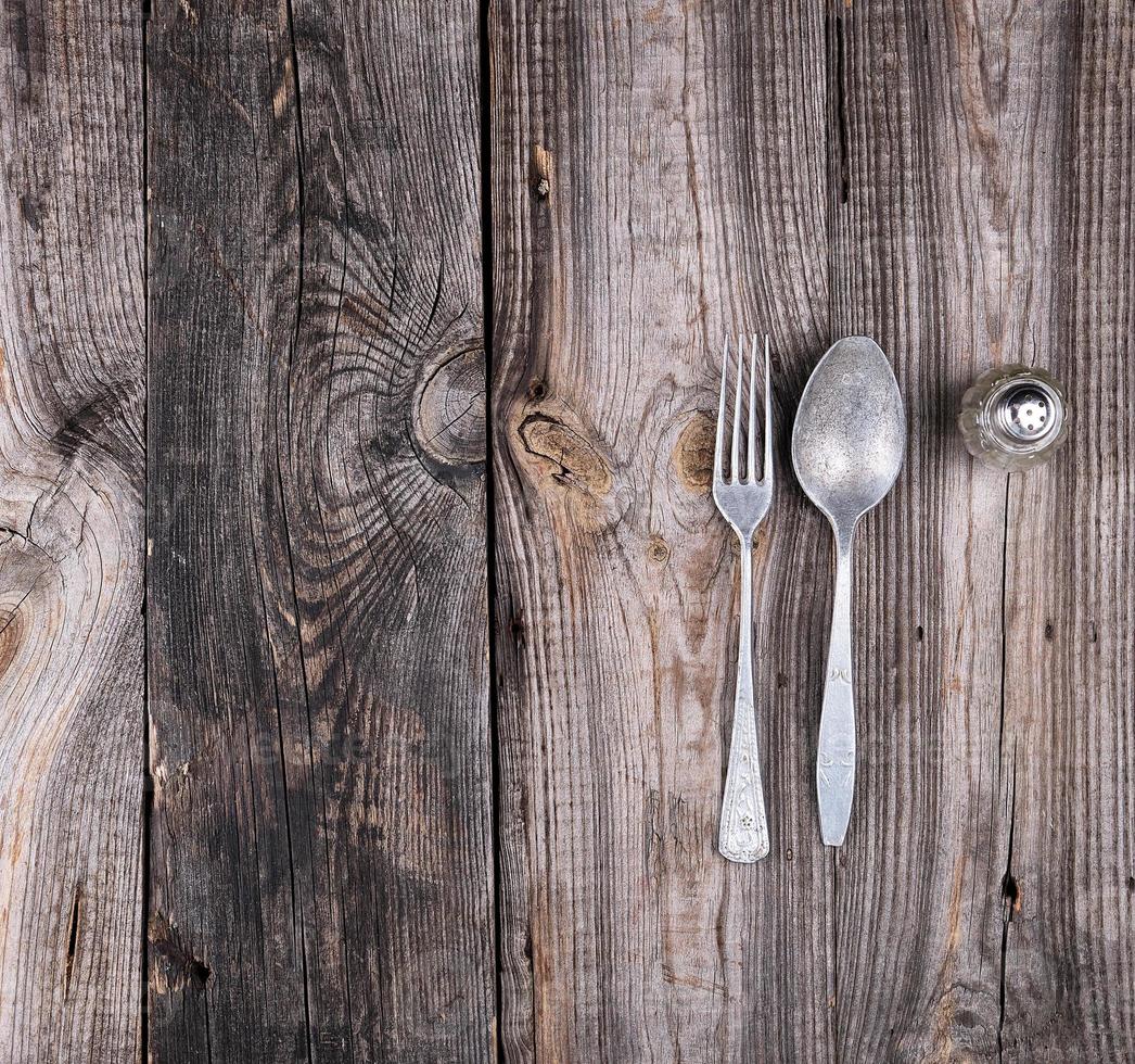 viejo aluminio falso y tenedor sobre una mesa de madera gris, vista superior foto