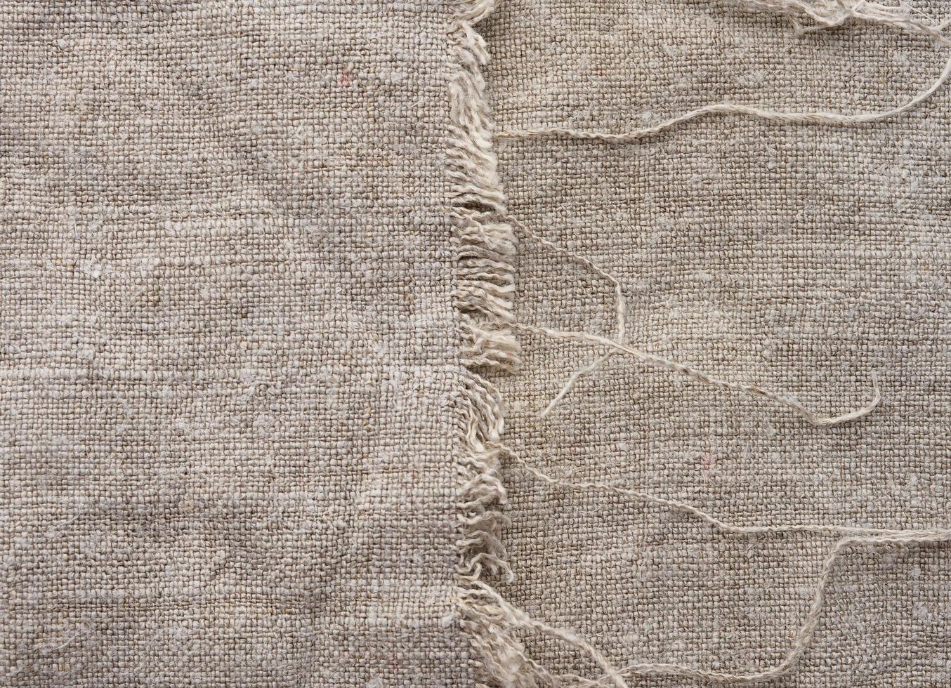 Gray linen fabric with frayed edges with thread photo