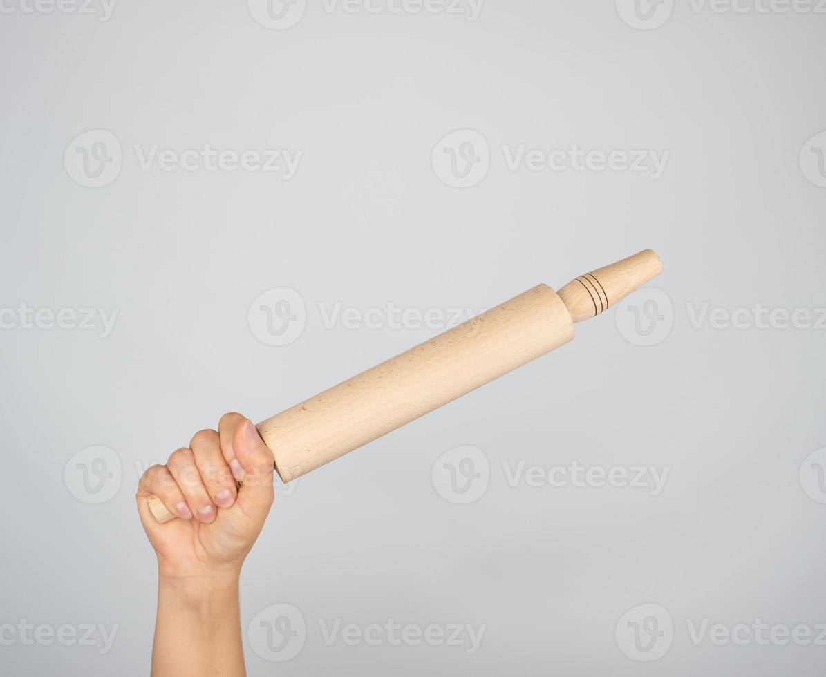 hand holding a wooden rolling pin photo