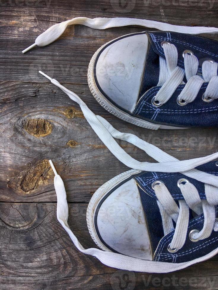 Old worn blue sneakers with white laces photo