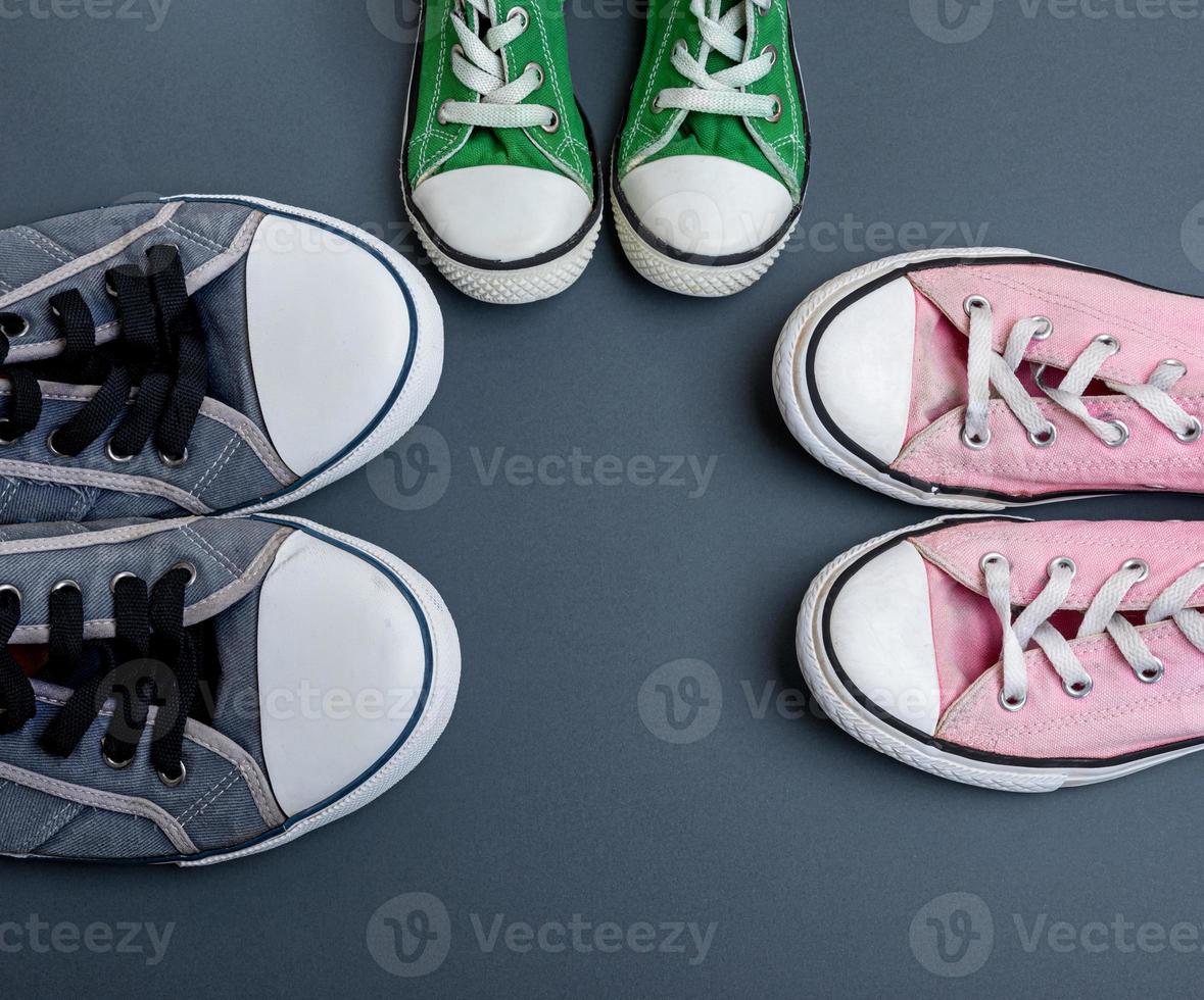 three pairs of textile worn sneakers photo