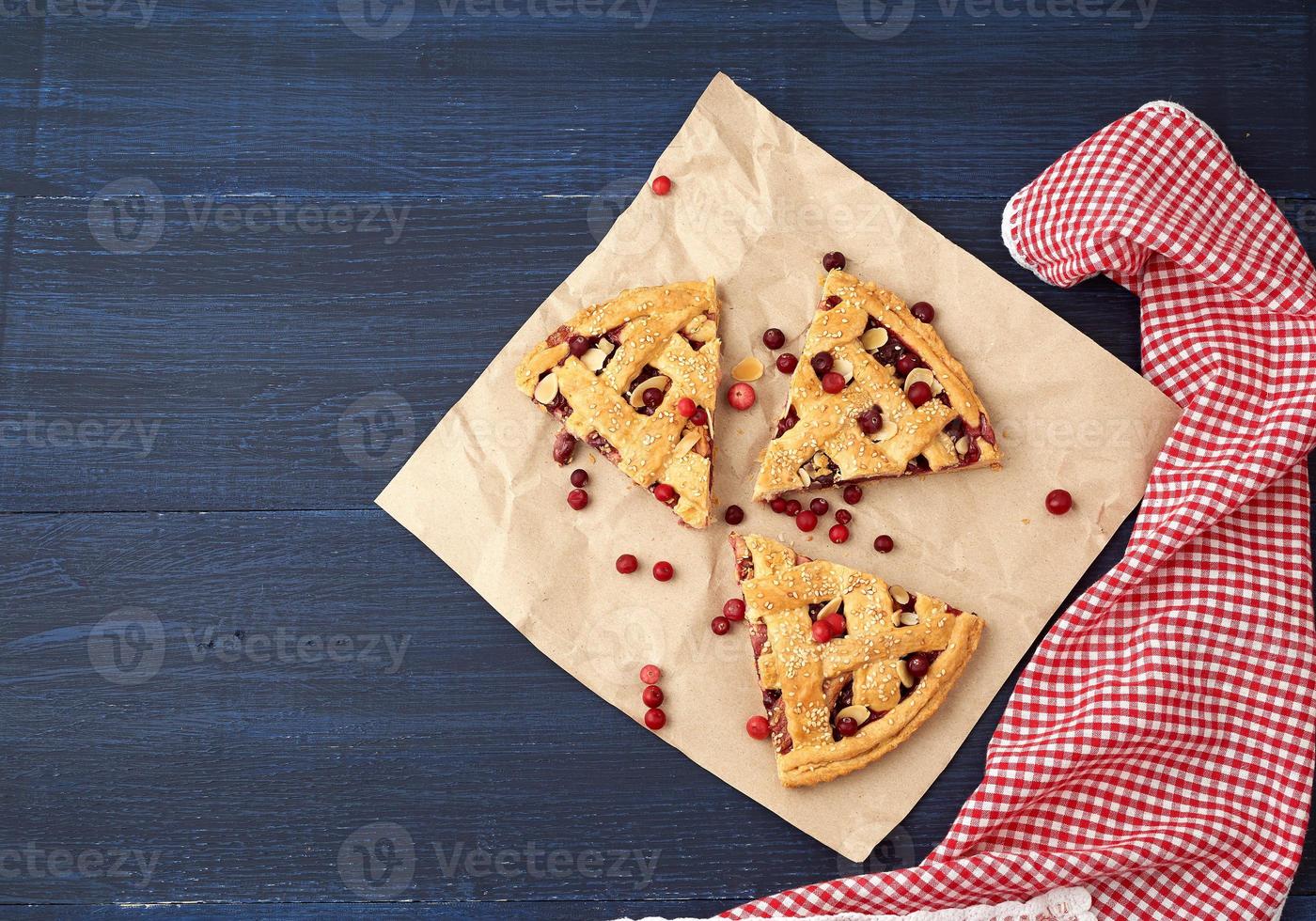 triangular slices of baked cranberry pie on brown paper photo