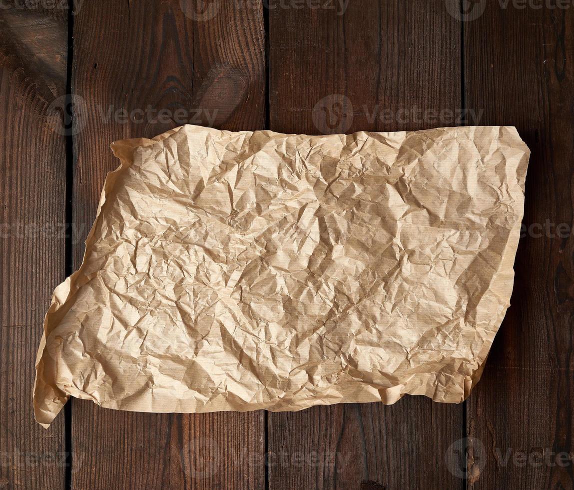 empty torn piece of brown crumpled baking paper on a table of boards photo
