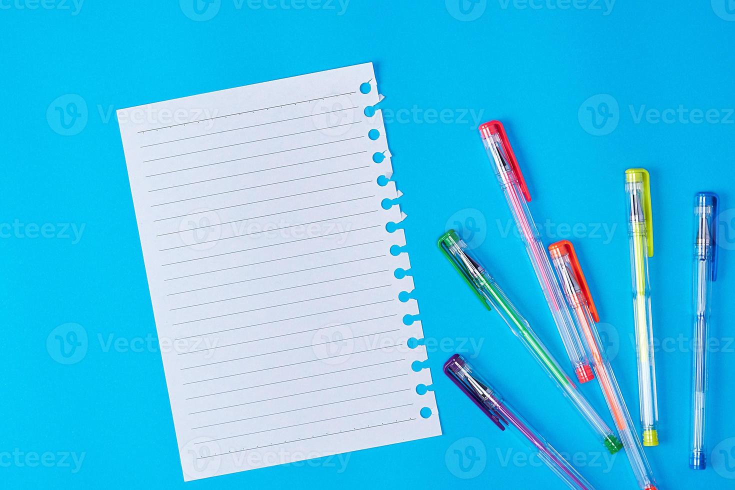 empty paper sheet in a line and multi-colored gel pens photo