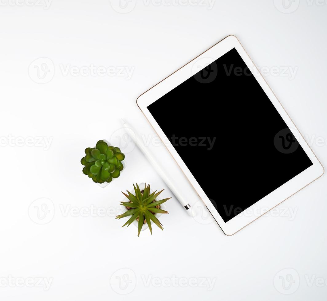 white electronic tablet with a blank black screen and a pencil photo