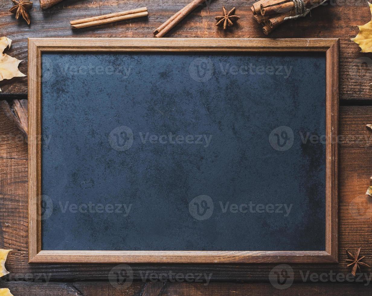 empty black chalk frame on brown wooden background photo