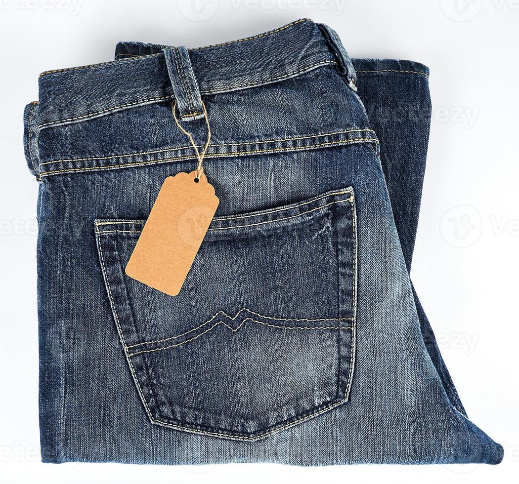 jeans azules doblados y etiqueta en blanco marrón atada foto