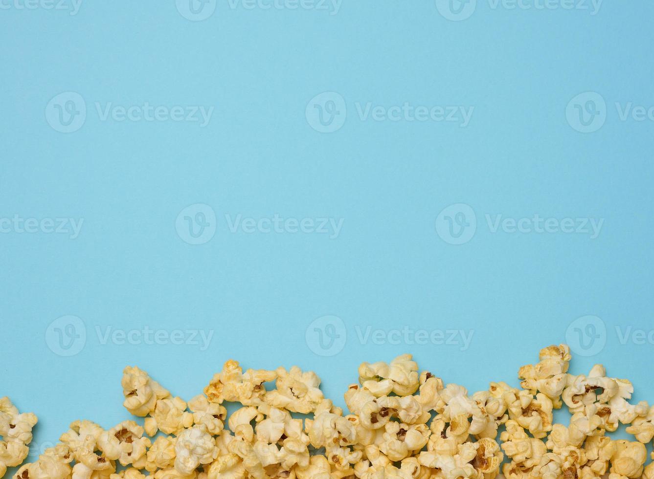 Heap of fried popcorn with cheese on a blue background photo