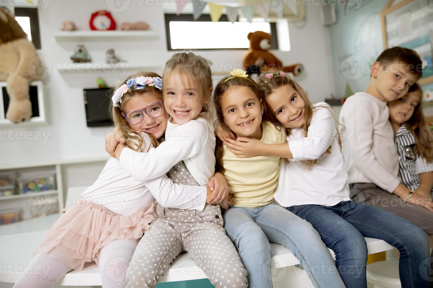 Group of kindergarten kid friends sitting and having fun photo