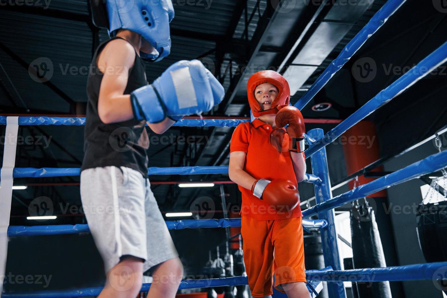 dos niños con equipo de protección tienen peleas y peleas en el ring de boxeo foto