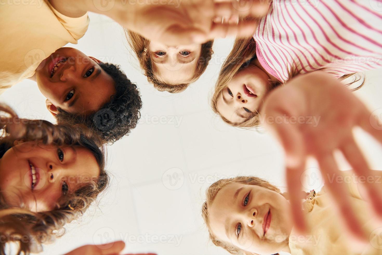 View from below. Children on celebrating birthday party indoors have fun together photo