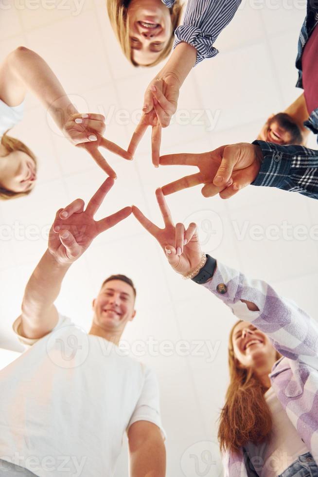 Making gesture by hands. Group of friends standing together photo