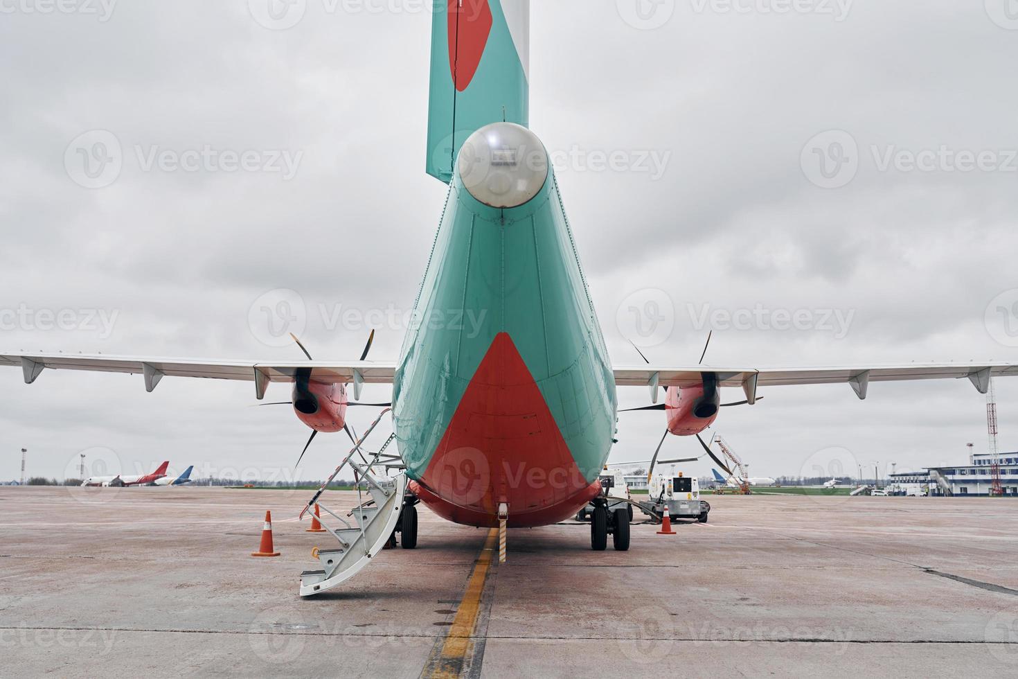 color naranja y azul. avión turbohélice estacionado en la pista durante el día foto