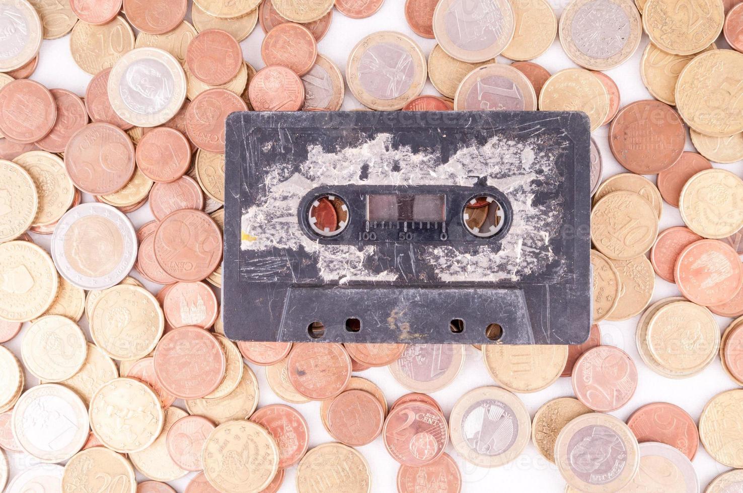 Cassette tape on coins background photo