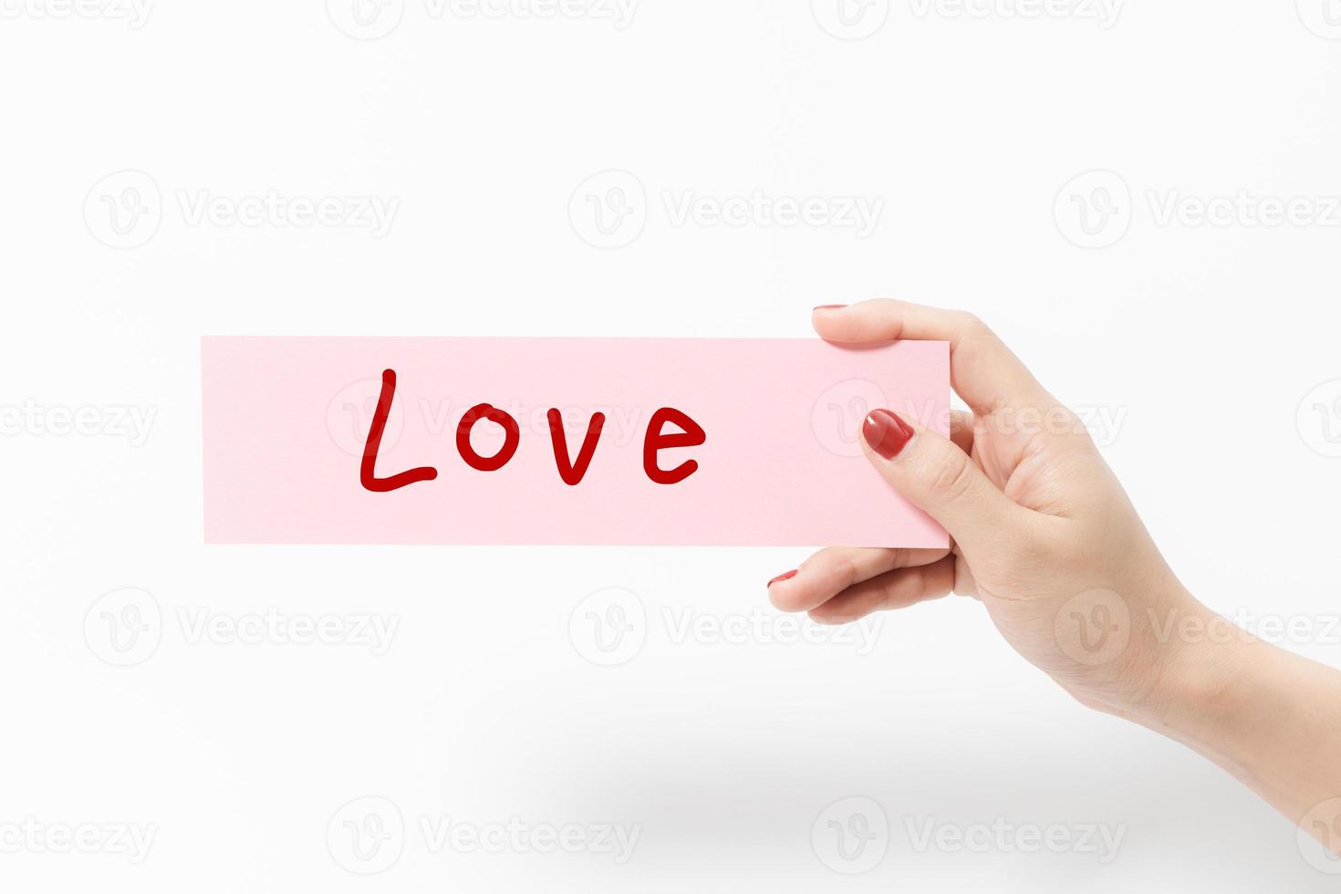 Close up women holding pink paper on white background. photo