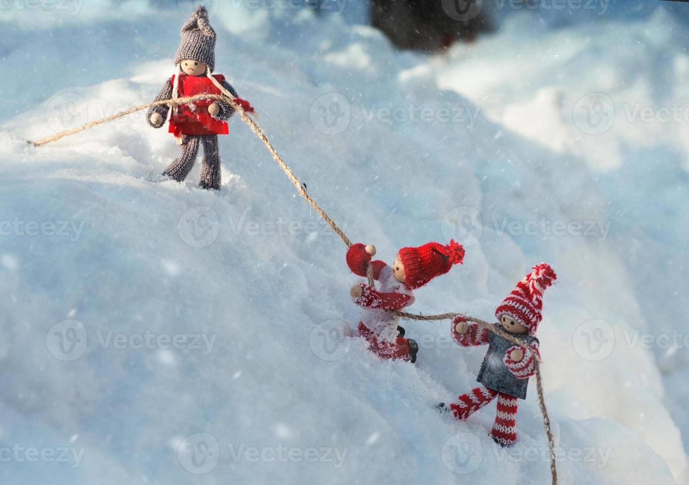 Two toy little man holding on to a rope photo